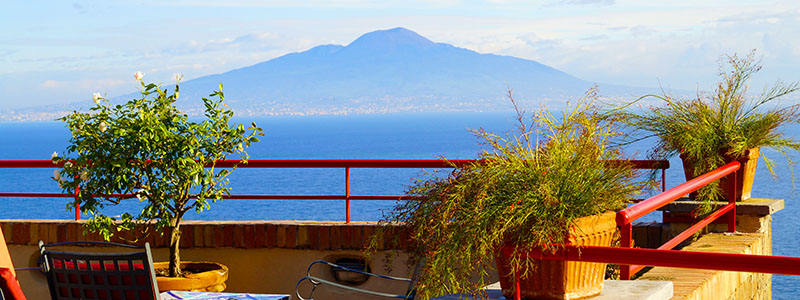 Uteplats med solstolar och vxter med utsikt ver havet och Vesuvius, Amalfi.