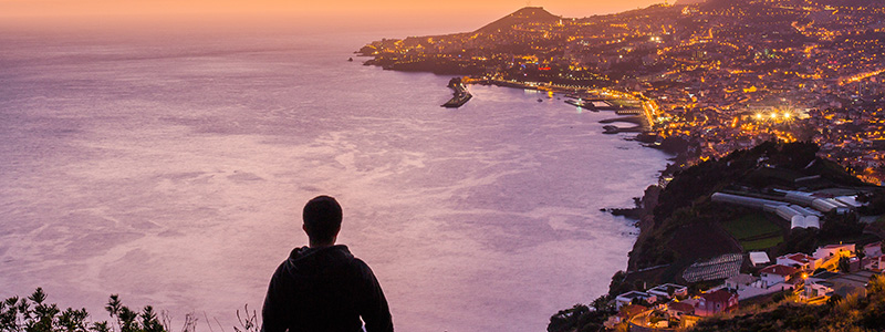 Madeiras huvudstad Funchal i rosa ljus i skymningen.
