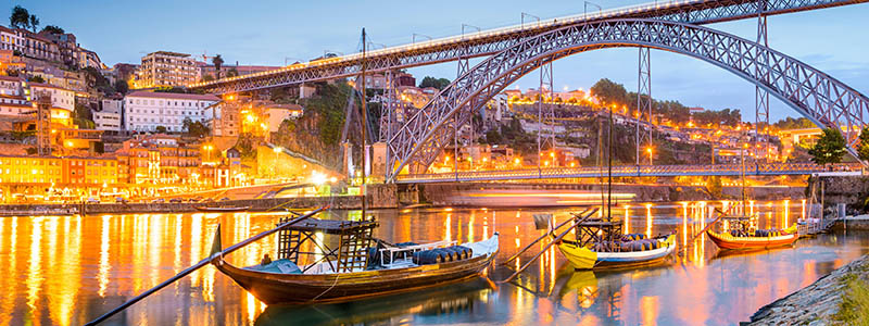 Hamnen i Porto med btar och bron i kvllsskrud, Portugal.