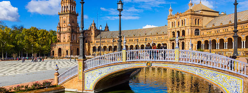 Spanska byn Sevilla med bron ver kanalen i Andalusien.