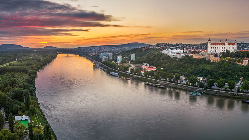 Floden Donau i kvllsljus med slottet i Bratislava i bakgrunden. 