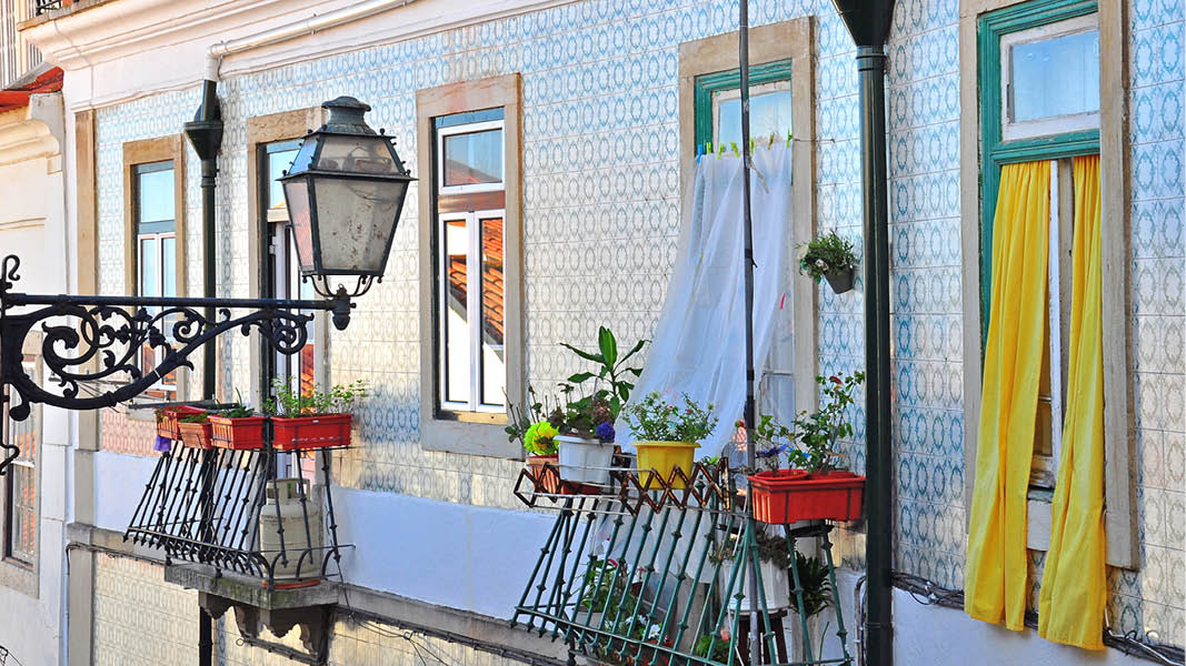 pittoreska fasader i lissabon med balkong och blommo p resa till portugal