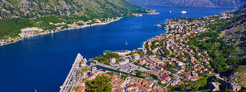 Vackra hamnen i Kotor med blått hav och grön natur i Montenegro.