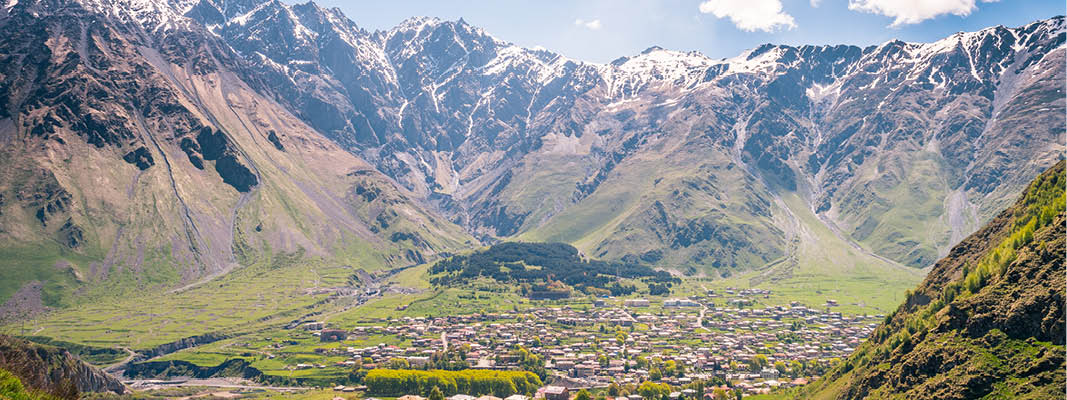 Stepantsminda med snöklädda berg i bakgrunden på en resa i Georgien.