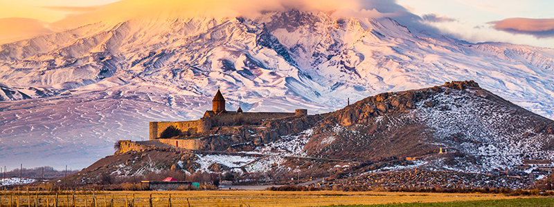 Klostret Khor Virap framför snötäckta berg i Armenien.