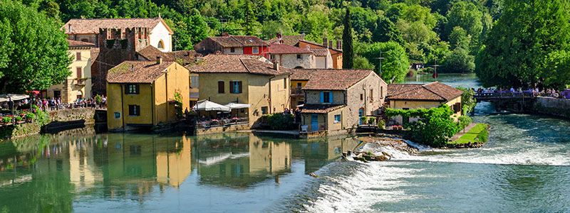 Borghetto med vattenkvarnar och idylliska hus vid floden, Italien.