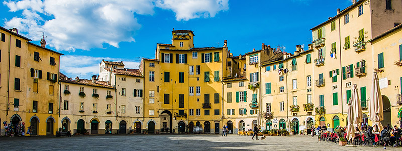 Torget i Lucca med de gula fasaderna och uteserveringarna.