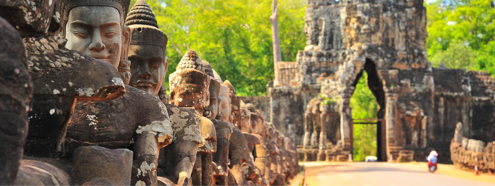 Statyer och tempel i gröna omgivningar i Angkor Thom, Kambodja.