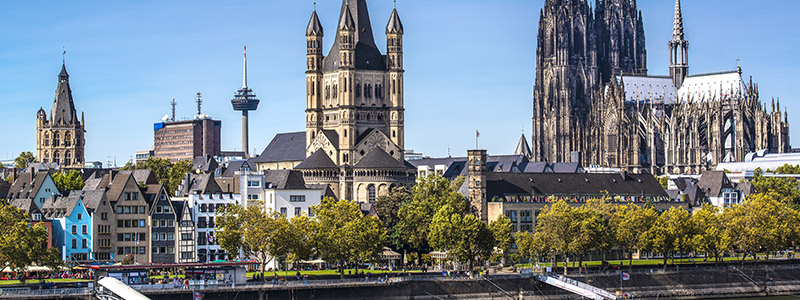 Vy över staden Köln och dess domkyrka mot klarblå himmel på flodkryssning genom Rhen.