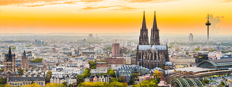 Vy över staden Köln och dess domkyrka mot klarblå himmel på flodkryssning genom Rhen.