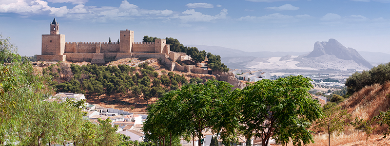 Fortet Alcazaba med skogen och bergen i omgivningarna i den spanska staden Antequera.