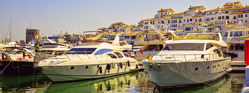 Den flådiga och lyxiga marinan med båtar i Puerto Banus, på en solsemester i södra Spanien.