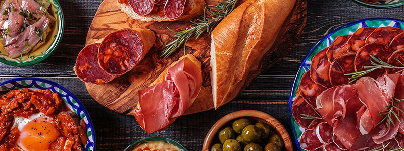 Spansk traditionell tapas med oliver, salami och skinka i Andalusien.