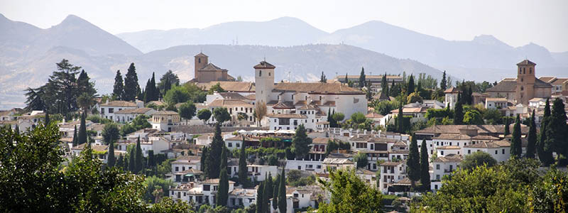 Bergsbyn Ronda på klippavsats med röd himmel på en resa till Andalusien.