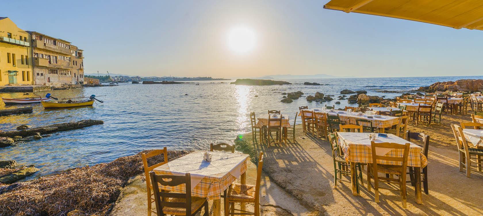 Uteservering vid havet i solnedgången i Grekland.