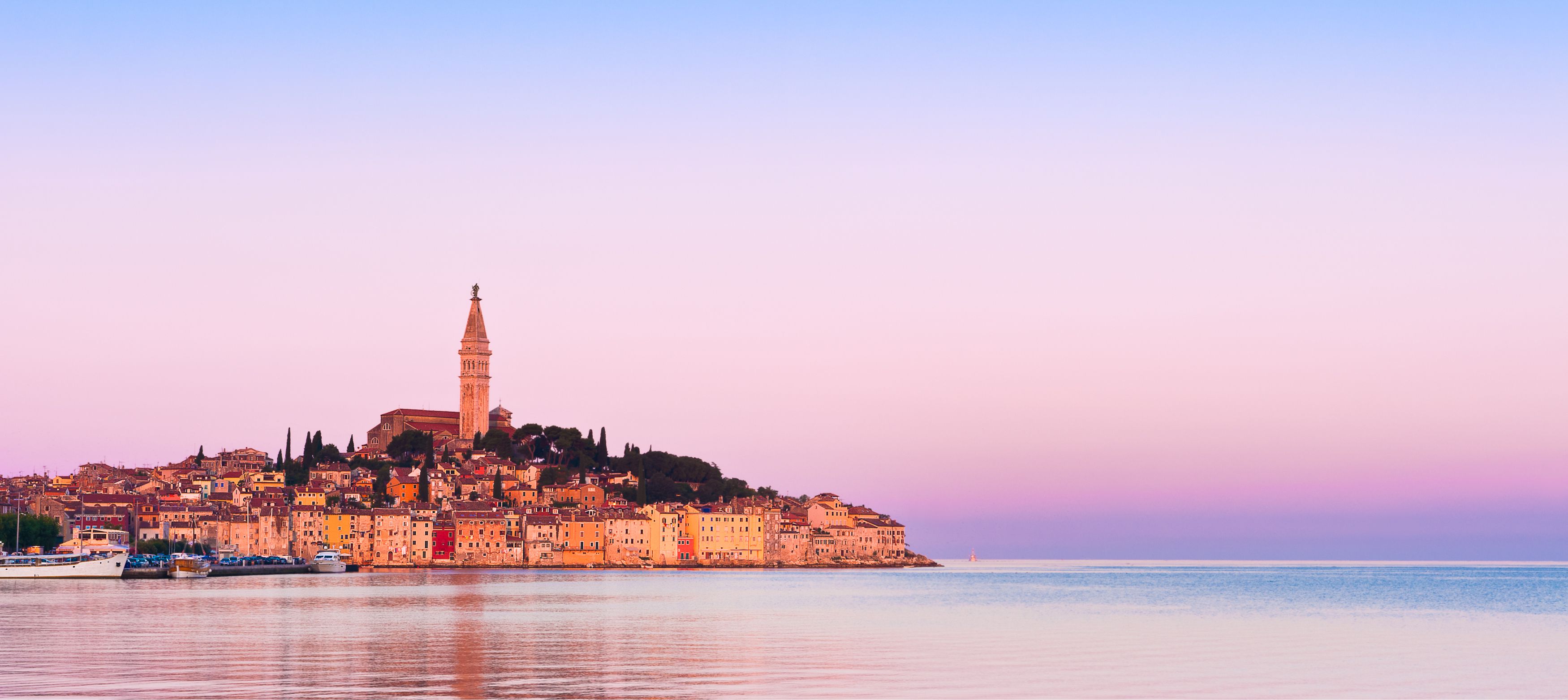 rovinj vid vattnet under en rosa himmel, kroatien