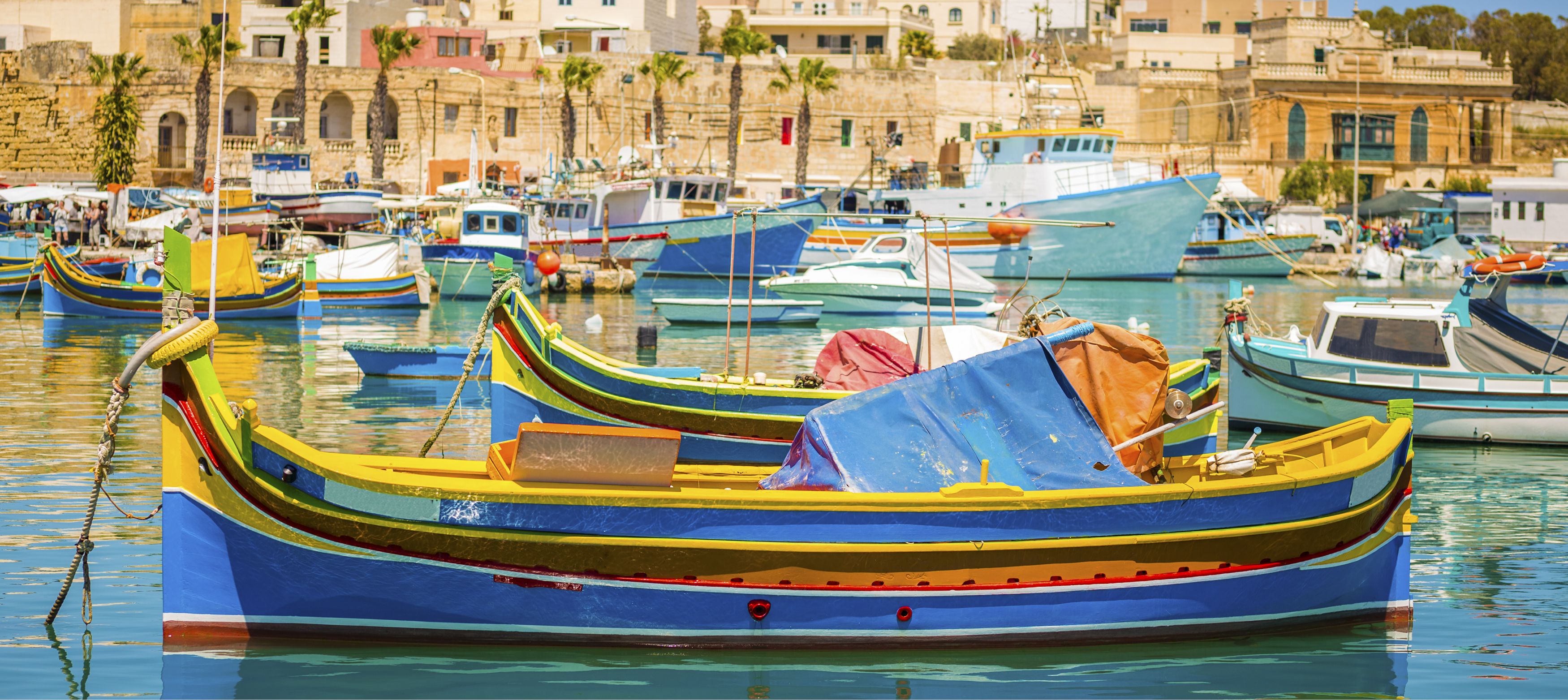 färgglada fiskebåtar intill hamnen vid palmer, malta