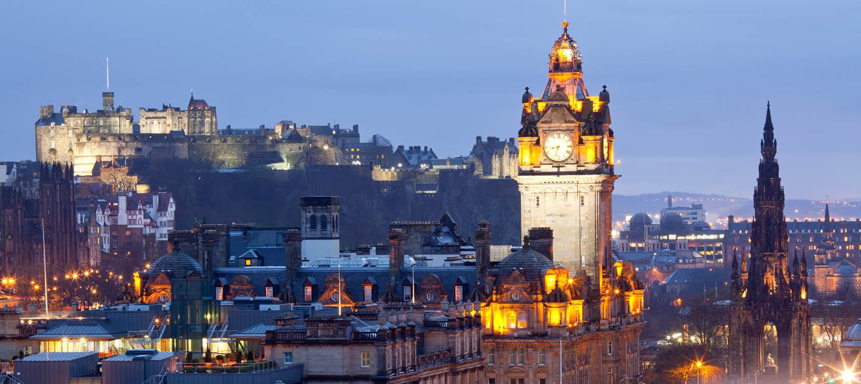 Edinburgh i kvllsljus med upplyst klocktorn p en resa till Skottland.