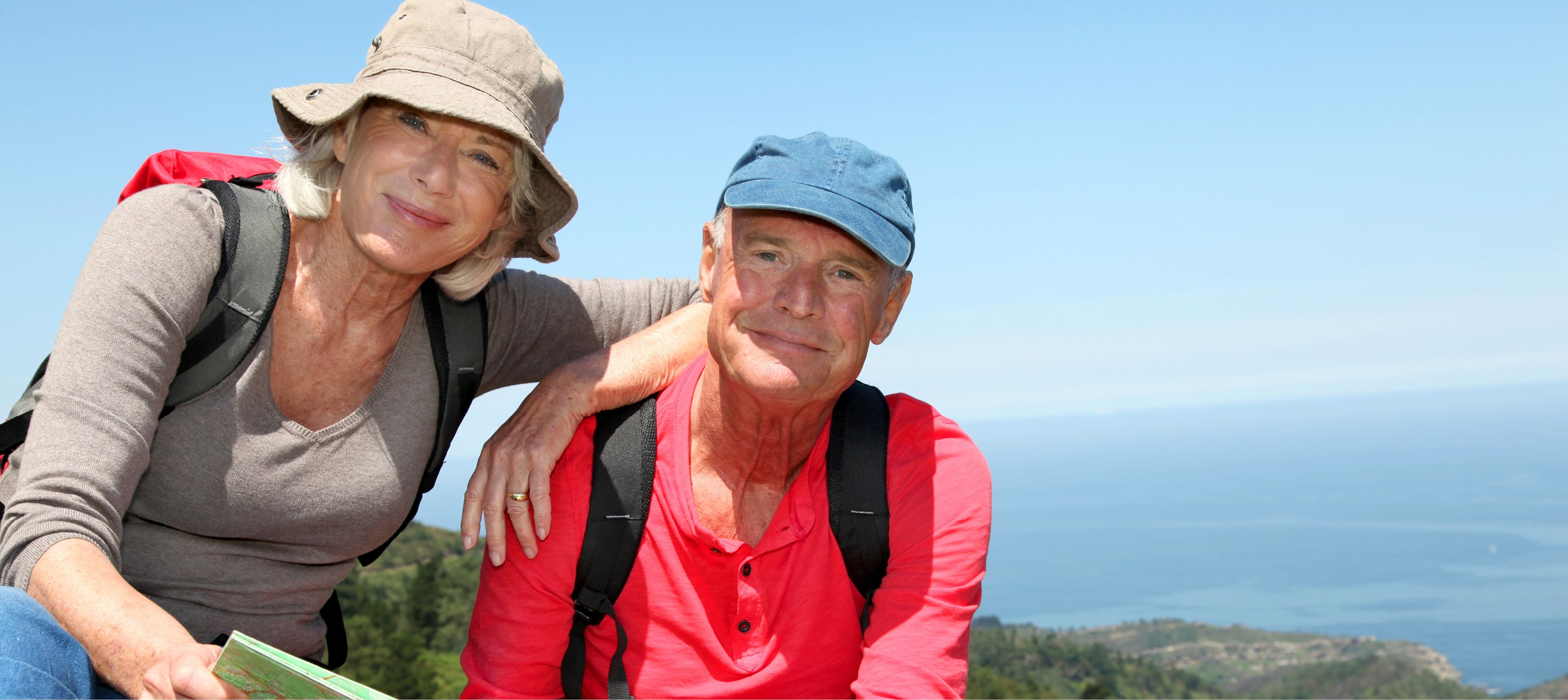 seniorpar som vandrar med karta bland vacker natur i europa