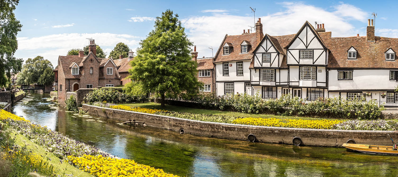 P en resa till England kan man uppleva brittisk stadsidyll med gamla hus och en bck och blommor