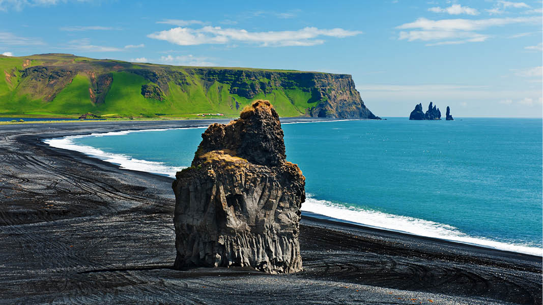 den svarta stranden med klippformationer i bakgrunden på resa till island