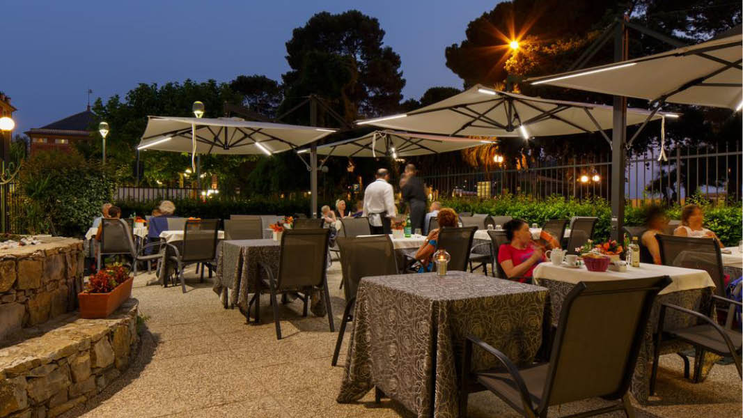 Middagsgster p en uteservering i kvllsljuset vid hotell Grande Albergo 4 stjrnor i Cinque Terre, Italien.