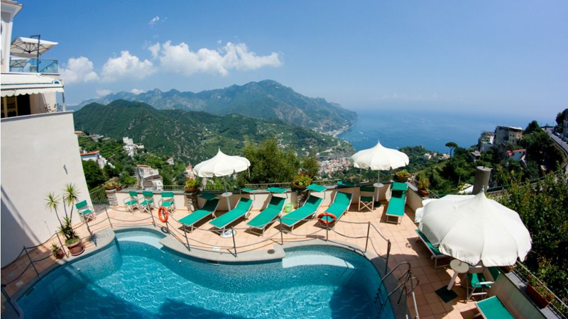 Utsikt ver poolterassen med havet och bergen i bakgrunden p hotell Bonadies lngs Amalfikusten.