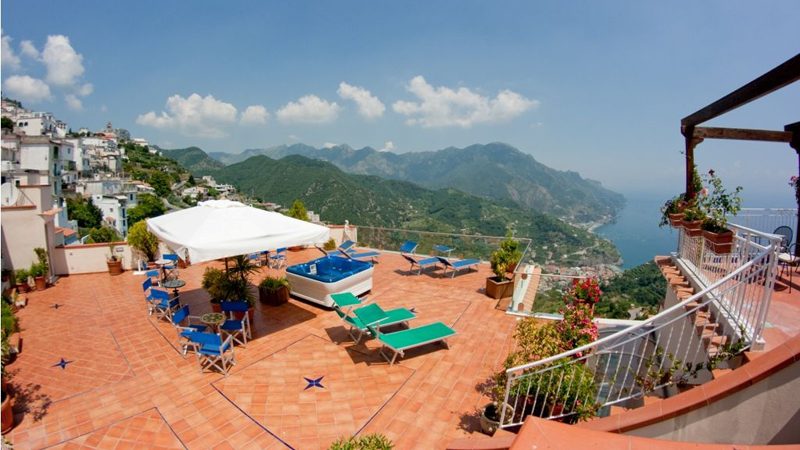 Utsikt över den rymliga utomhusterassen där solstolar står uppradade på hotell Bonadies längs Amalfikusten.