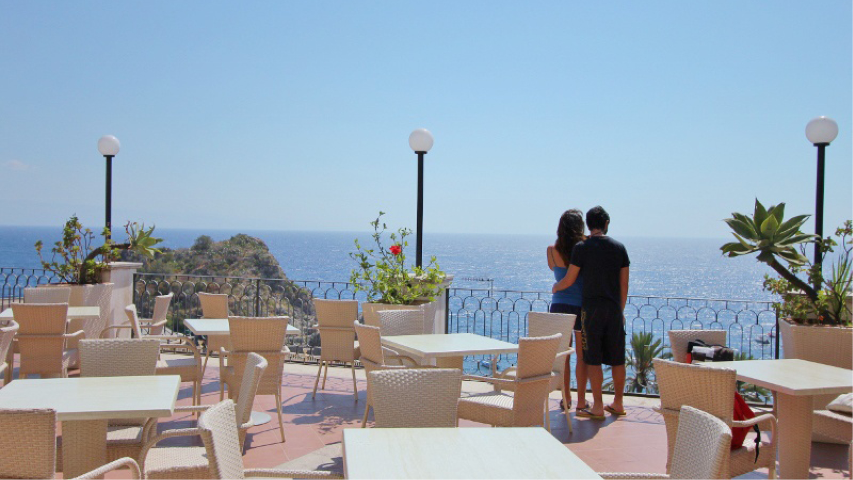 Par p semester som blickar ut mot ett ppet hav p hotell Baia Azzurra nedanfr Taormina, Sicilien.
