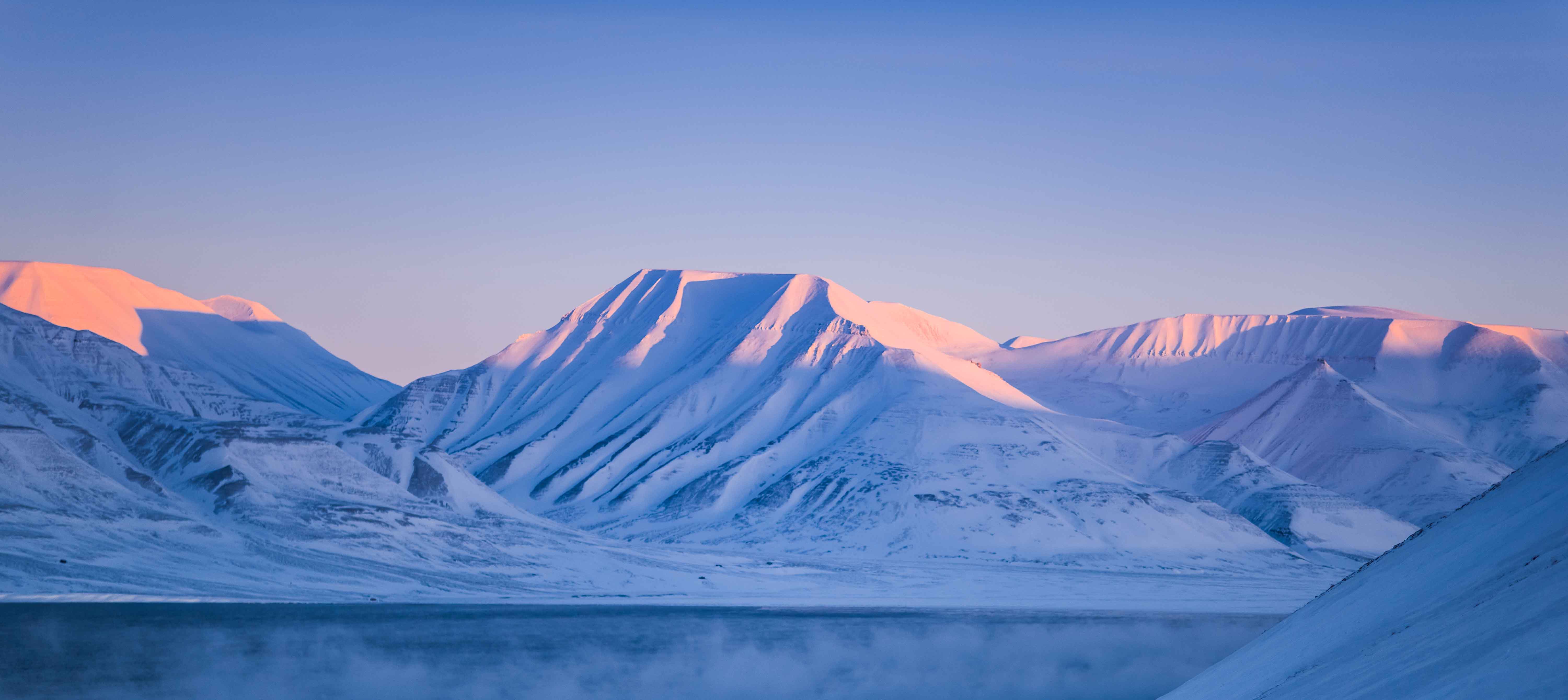 Snkldda berg vid en sj p Svalbard.
