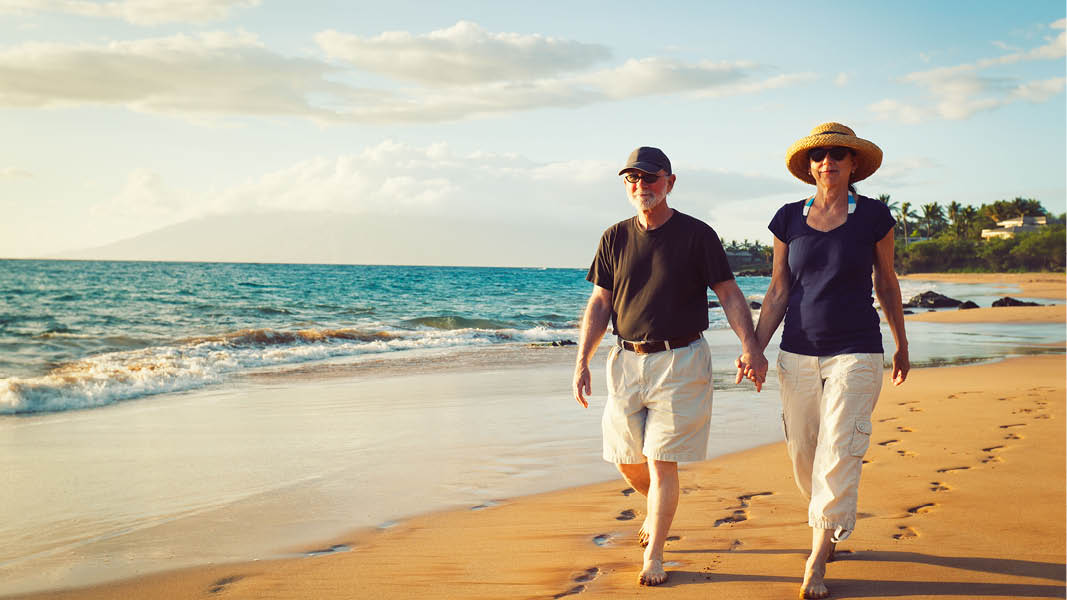 par som vandrar längs stranden vid havet på ett soligt algarvekusten i portugal