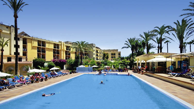 Det stora poolomrdet med solstolar, palmer och poolbar vid hotel Sol don Pedro i Torremolinos, Andalusien.