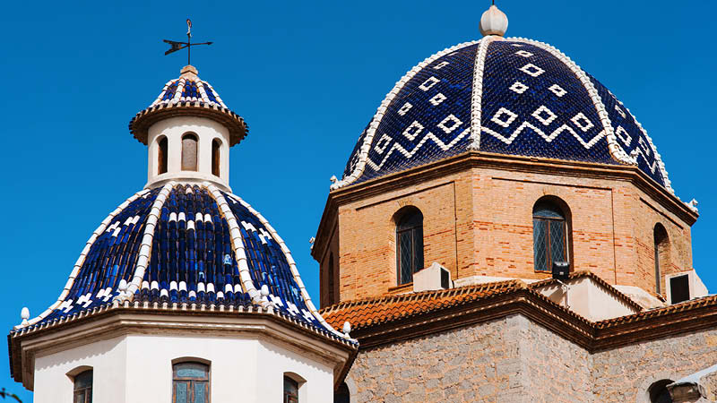 Kyrktornen p kyrkan Parroquia De Nuestra Seora Del Consuelo i Altea i Spanien.