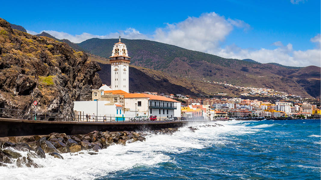 Candelaria basilikan med berg i bakgrunden och stormiga vgor p Teneriffa.